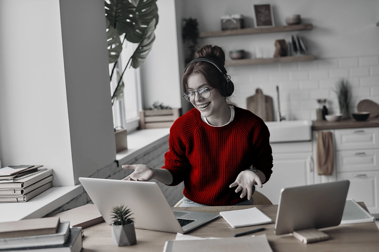 Lady studying / smiling at her laptop.